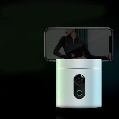 Smart rotating phone holder with built-in camera, smartphone mounted on top, dark background