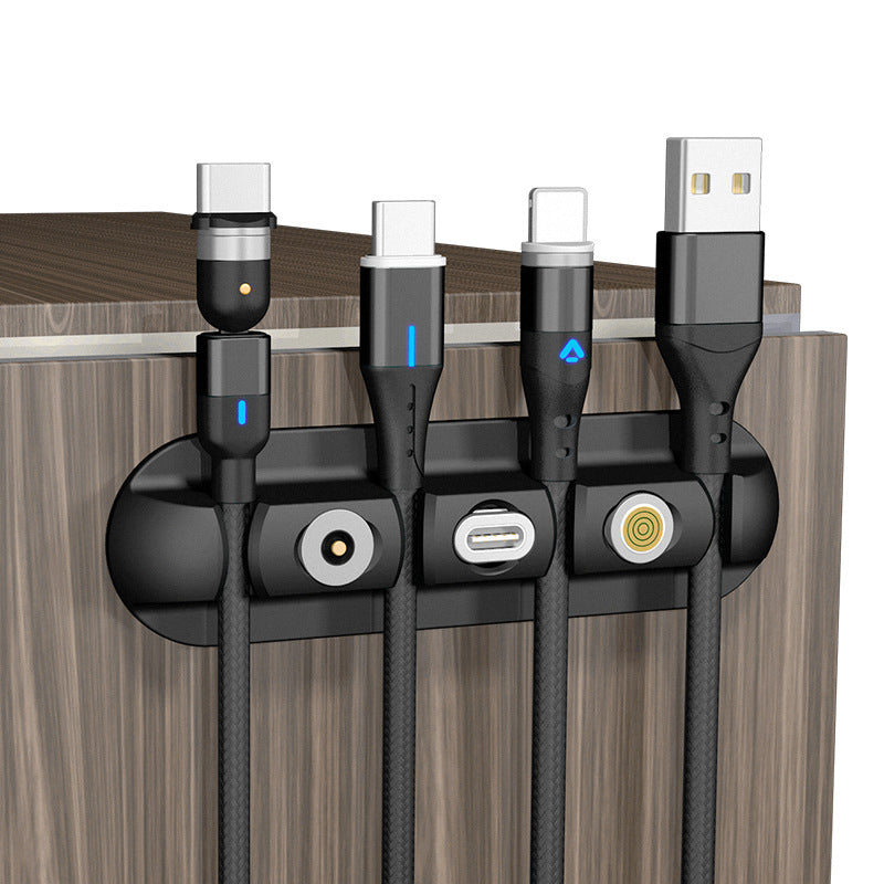 Magnetic cable organizer holding multiple charging cords on a wooden desk edge