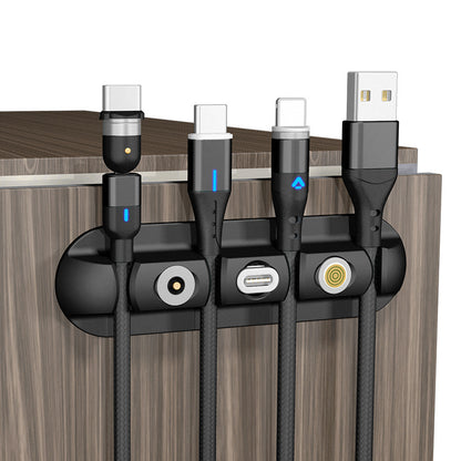 Magnetic cable organizer holding multiple charging cords on a wooden desk edge