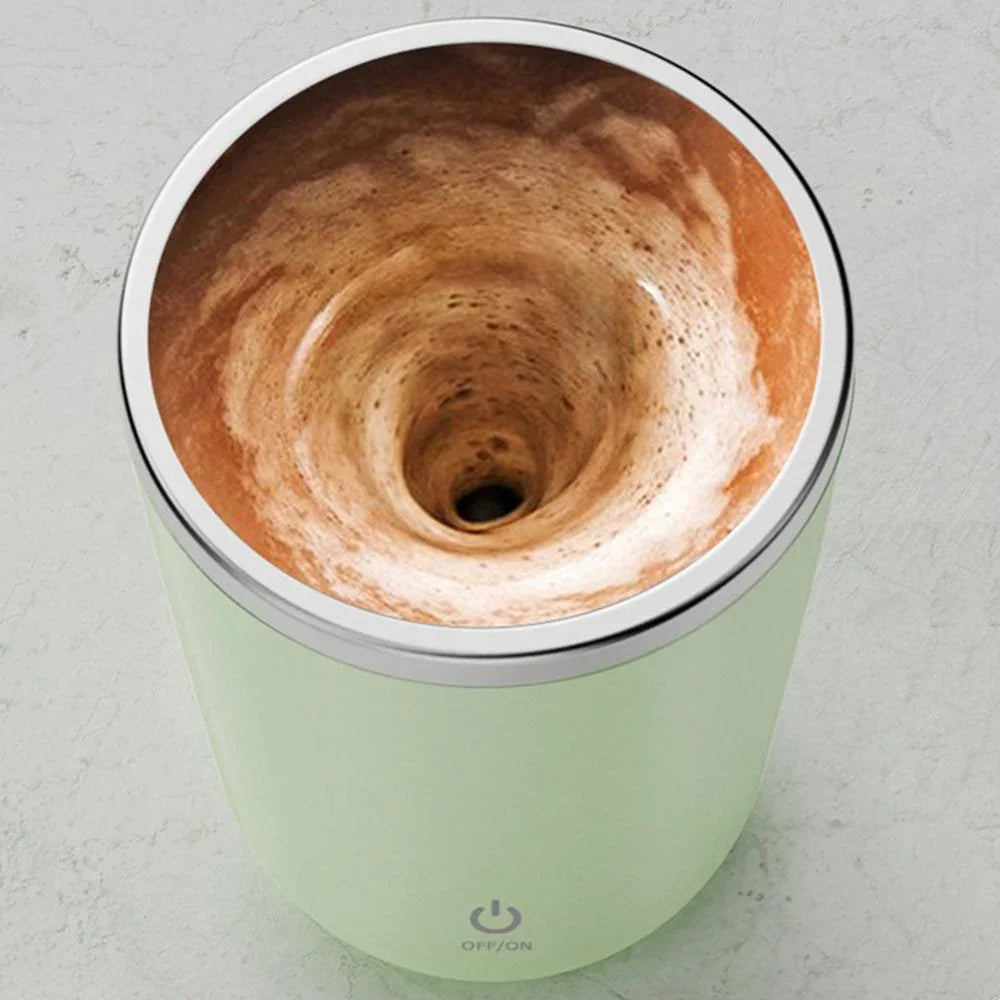 Automatic electric frother mug mixing coffee with foam swirl on a countertop