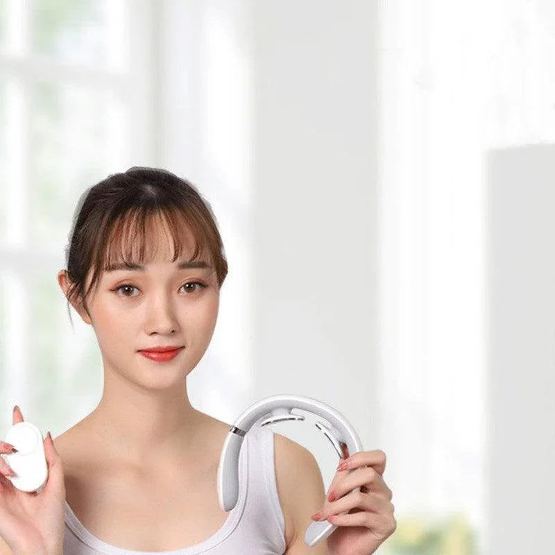 Woman holding electronic neck massager and remote control in bright home setting