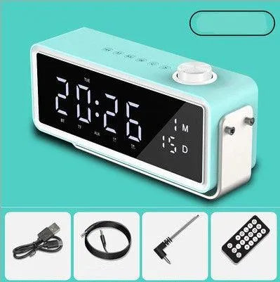 Modern turquoise digital alarm clock with large LED display, volume knob, USB cable, audio cable, adapter, and remote control