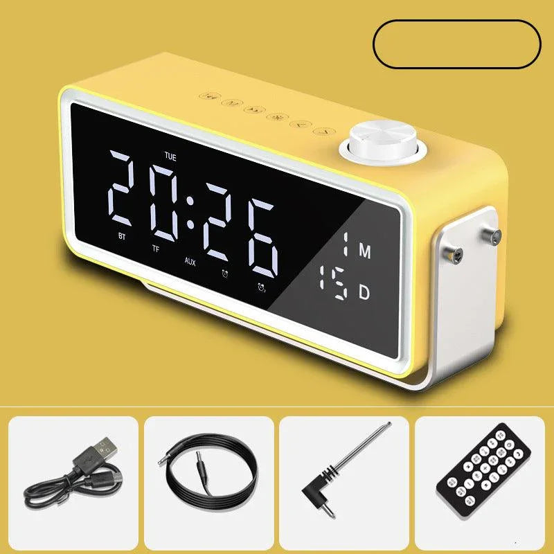 Yellow digital alarm clock with temperature display and control knob, plus USB cable, audio cable, adapter, and remote